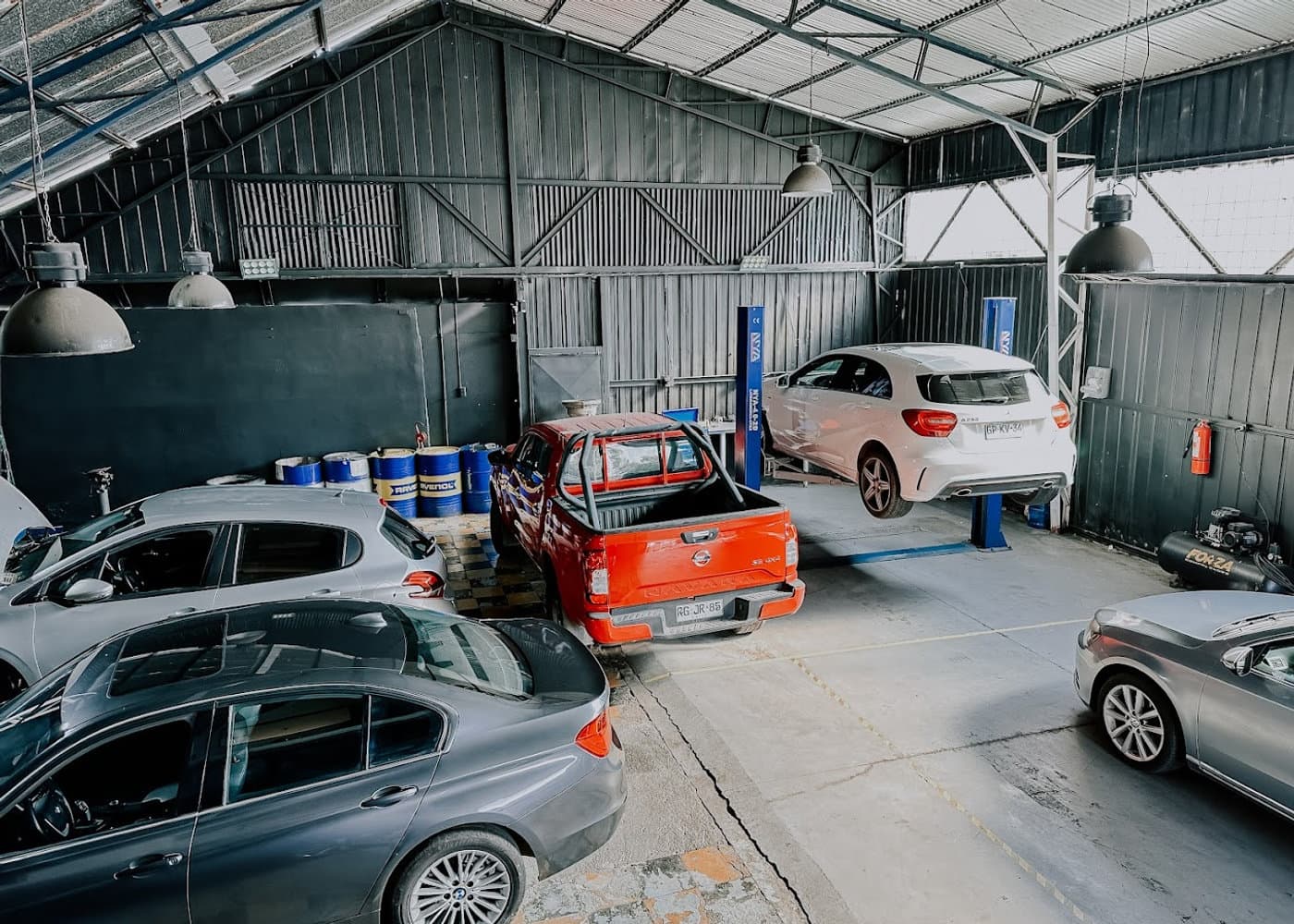 Interior del taller Jotamotors con vehículos y elevadores